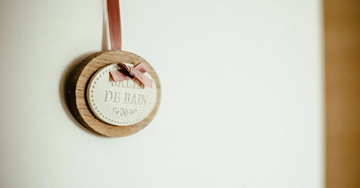 Elegante Holzschild mit dem Text 'Salle de Bain', ausgestattet mit einem rosa Band, ideal für moderne Badezimmerdekoration.
