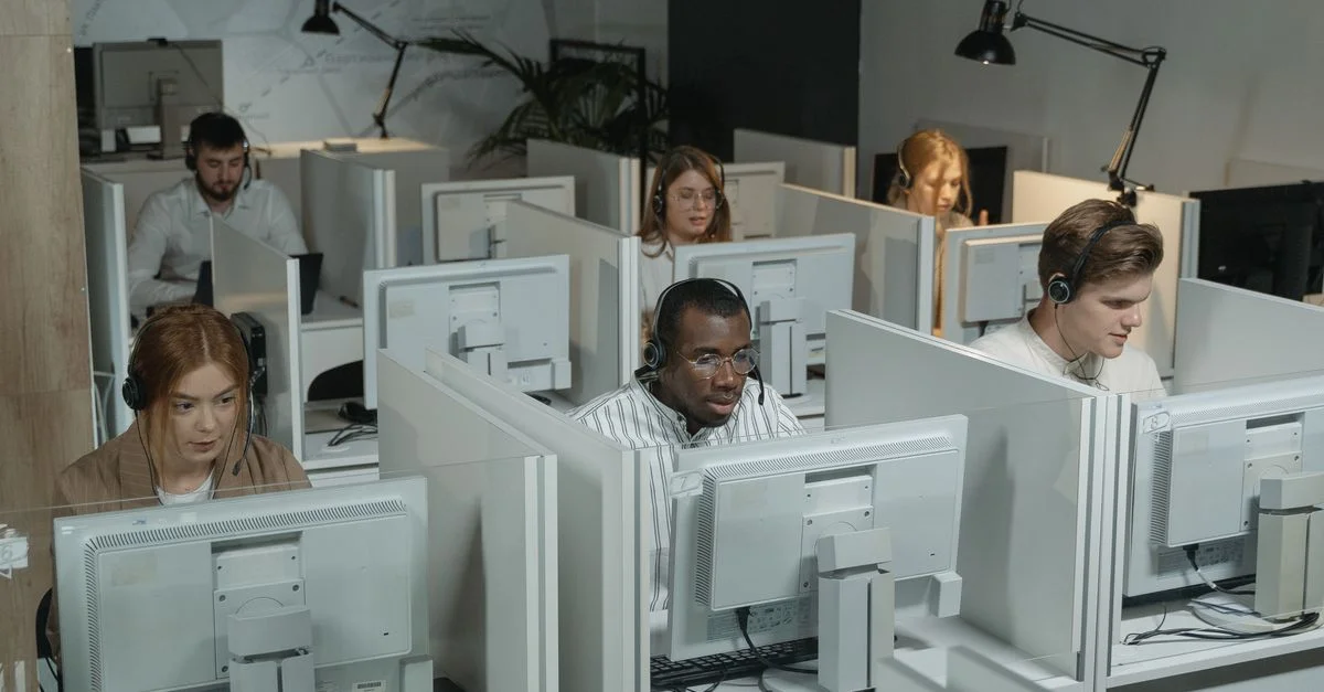 Professionelles Kundenserviceteam arbeitet mit Headsets in einer modernen Büroumgebung.