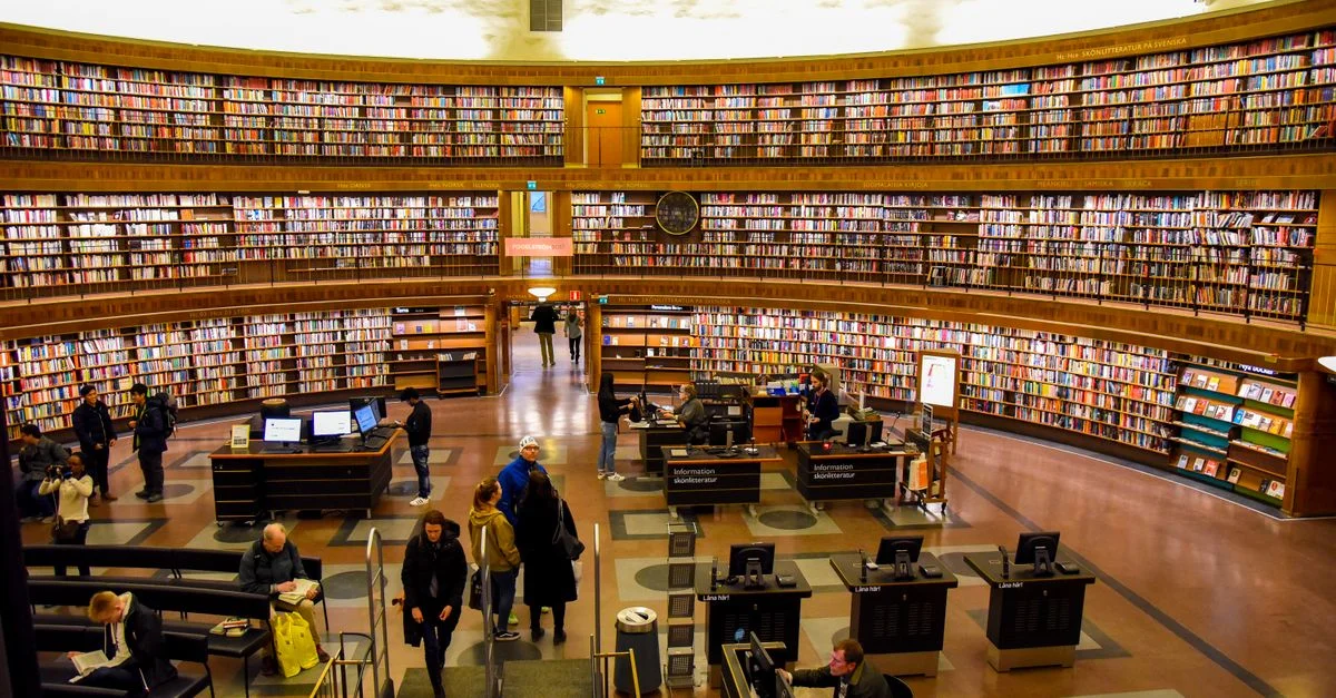 Lebhafte Aussicht in der Stockholmer Stadtbibliothek, die Besucher und Bücherregale zeigt.